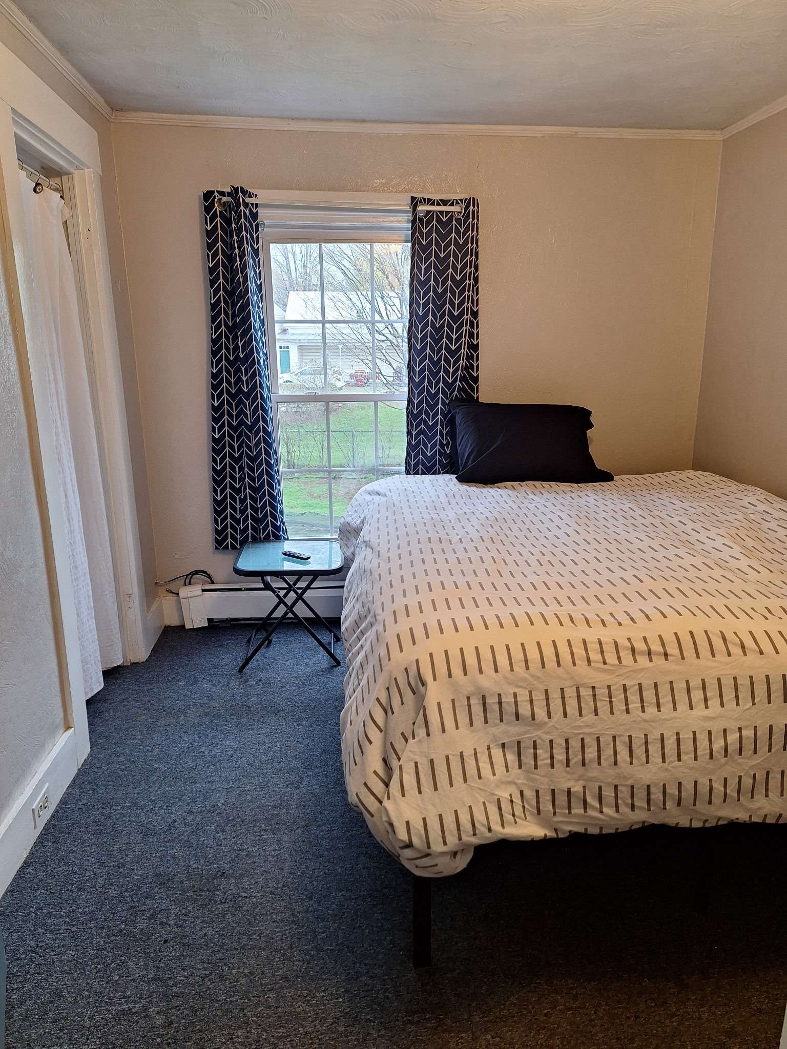 Modern bedroom with window view and patterned bedding in Skowhegan contractor housing