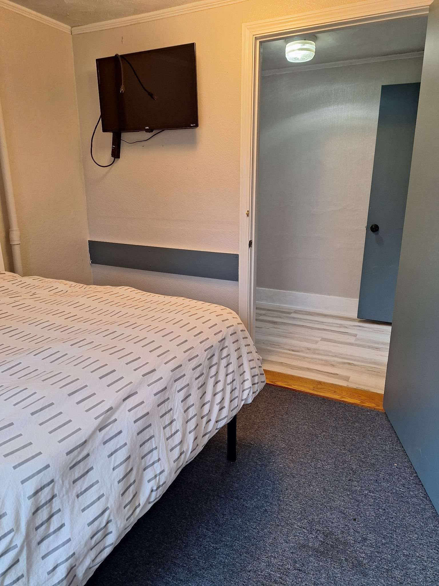 Bedroom with wall-mounted TV for contractors in Skowhegan rental - entertainment included