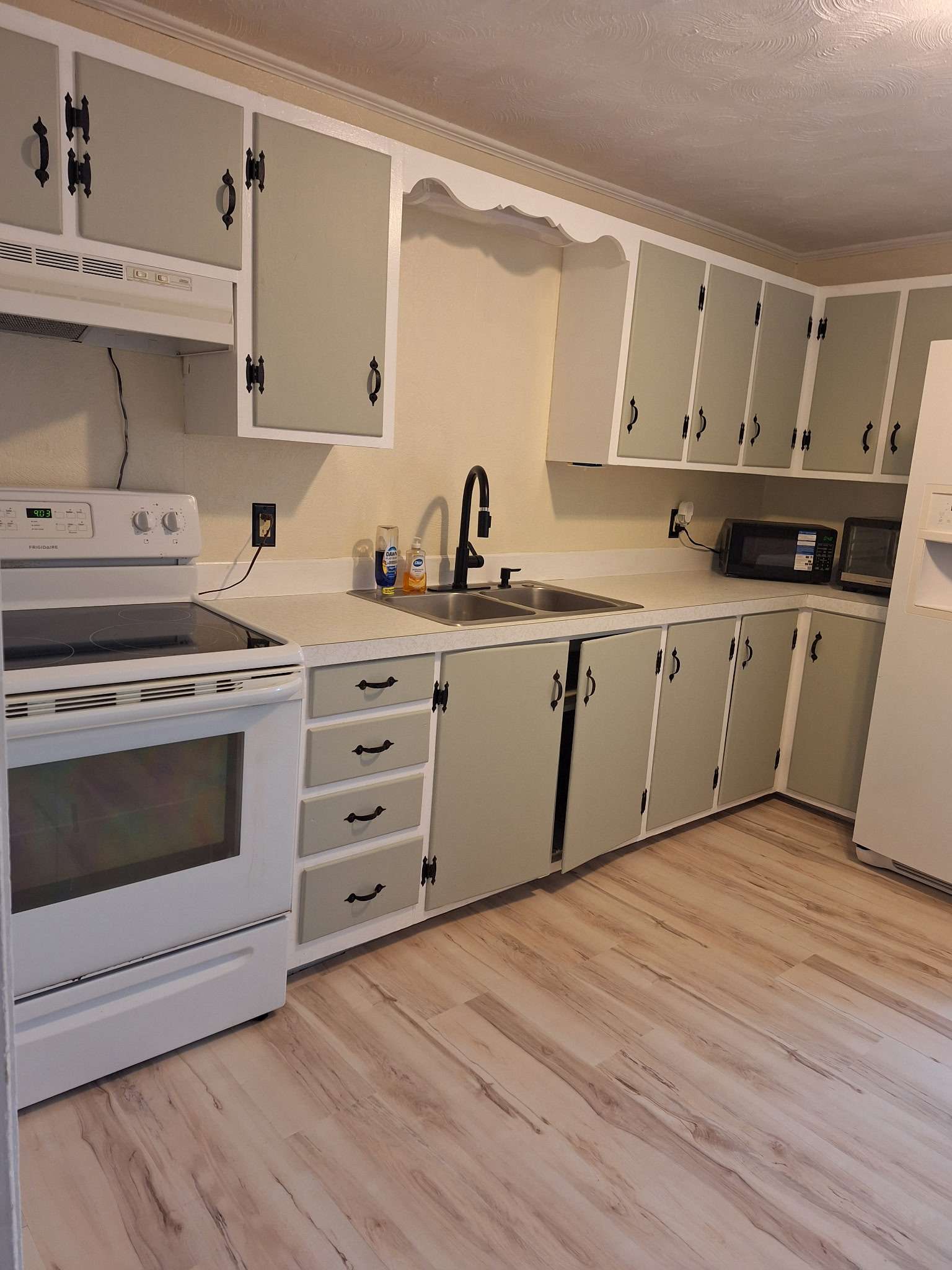 Spacious kitchen with white cabinets and appliances in Skowhegan contractor rental - fully equipped