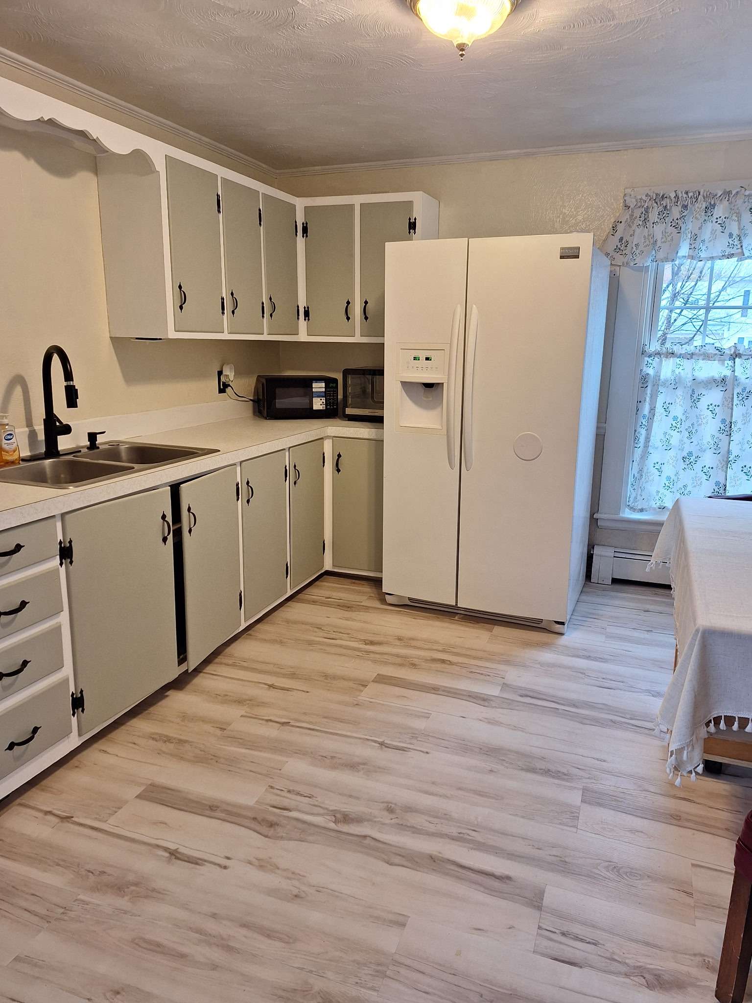 Kitchen with refrigerator and ample storage in Skowhegan contractor housing - all utilities included