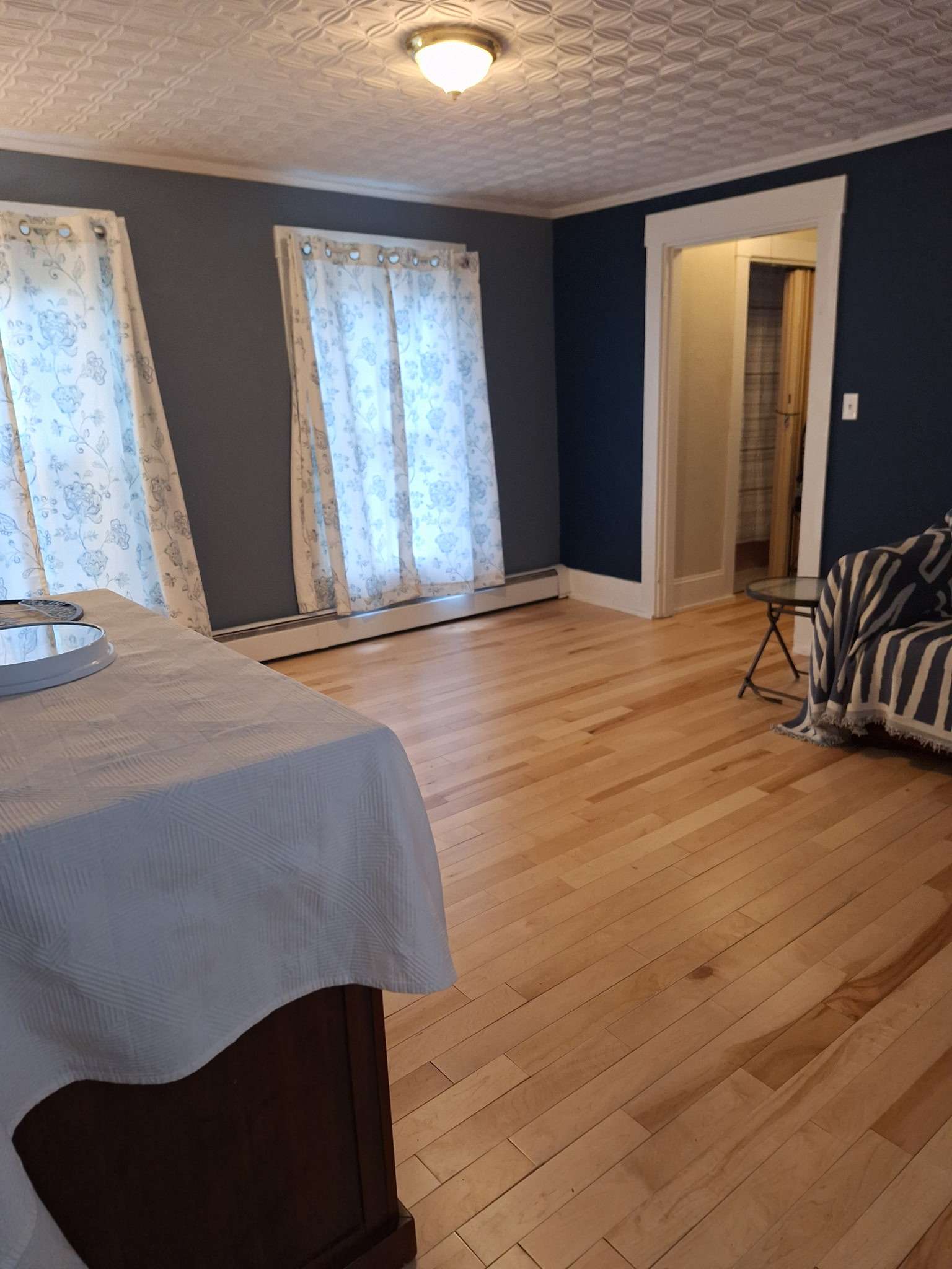 Living room with blue walls and hardwood floors in Skowhegan contractor rental - comfortable space