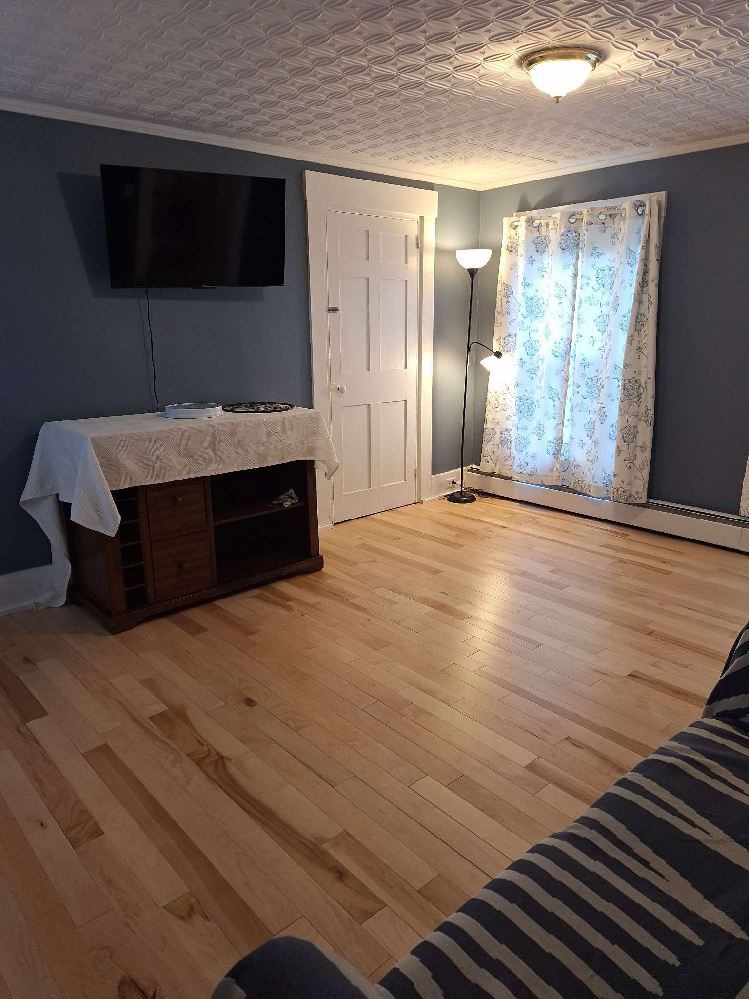 Living area with wall-mounted TV and comfortable seating in Skowhegan contractor housing
